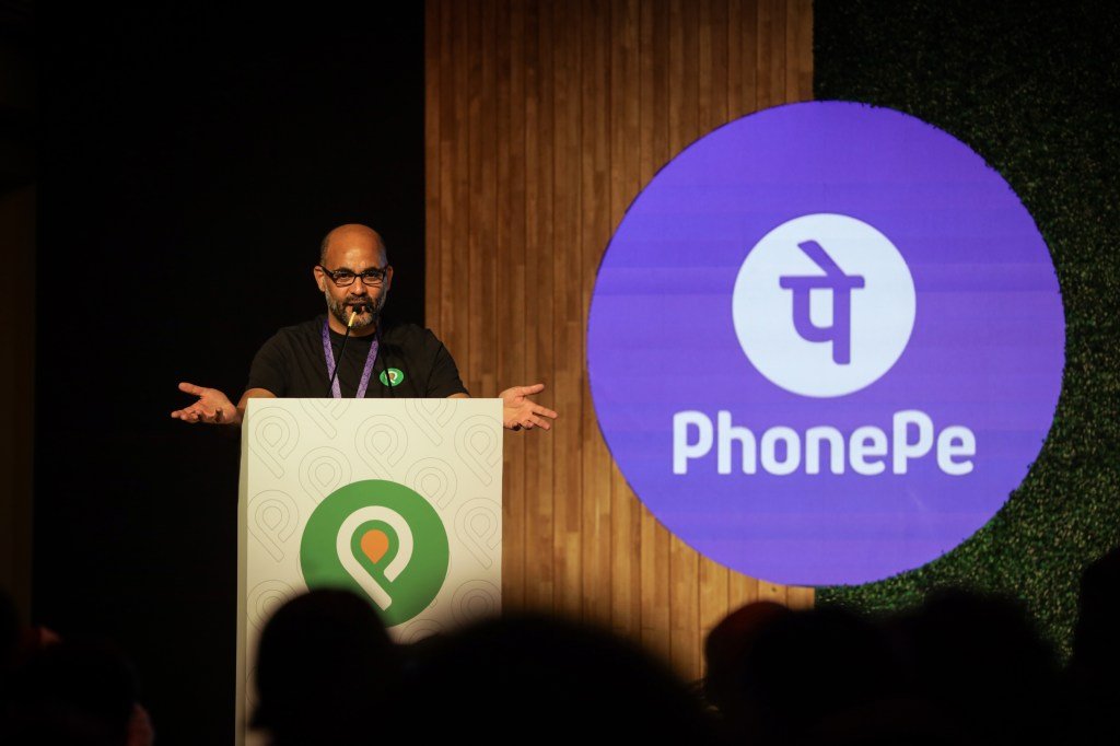 Homme parlant sur un podium avec le logo PhonePe affiché sur le côté