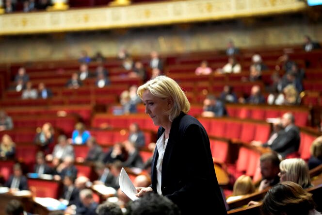 Marine Le Pen marche pour prononcer son discours à l'Assemblée Nationale le mardi 12 mars 2024. 