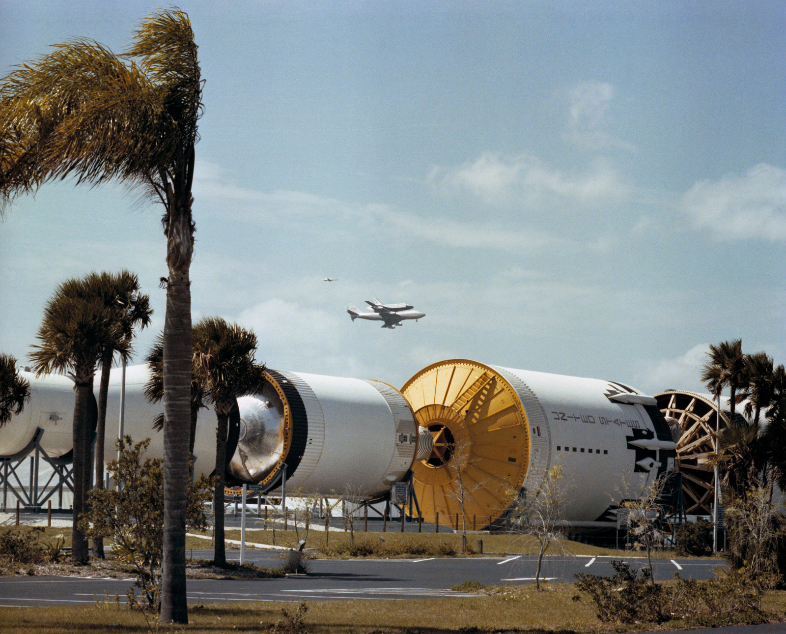 La navette spatiale Columbia au sommet de son Shuttle Carrier Aircraft (SCA) survole l'exposition Saturn V au Kennedy Space Center (KSC) de la NASA en Floride.