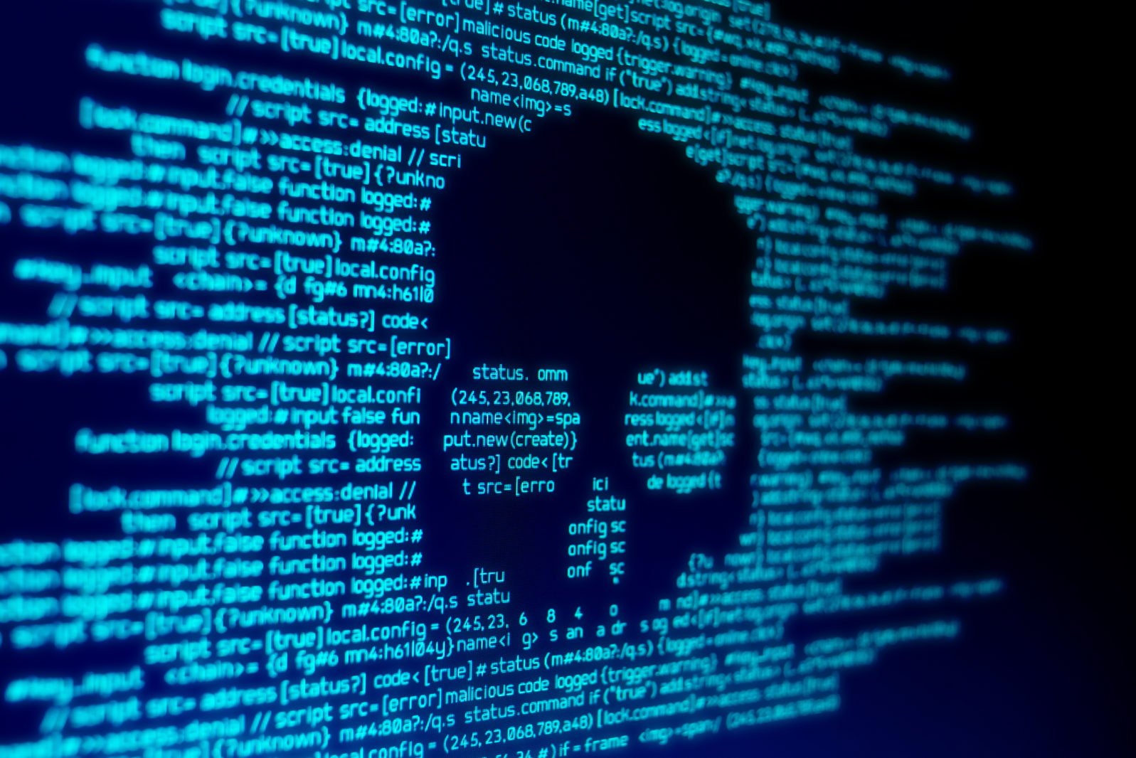 Code informatique sur un écran avec un crâne représentant une attaque de virus informatique/malware.