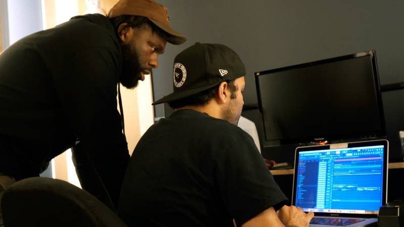 Deux artistes regardent ensemble un ordinateur.