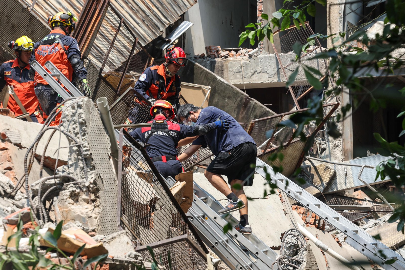 Une photo de la Central News Agency montre des secouristes aidant un survivant après qu'il ait été secouru d'un bâtiment endommagé dans la ville de New Taipei.