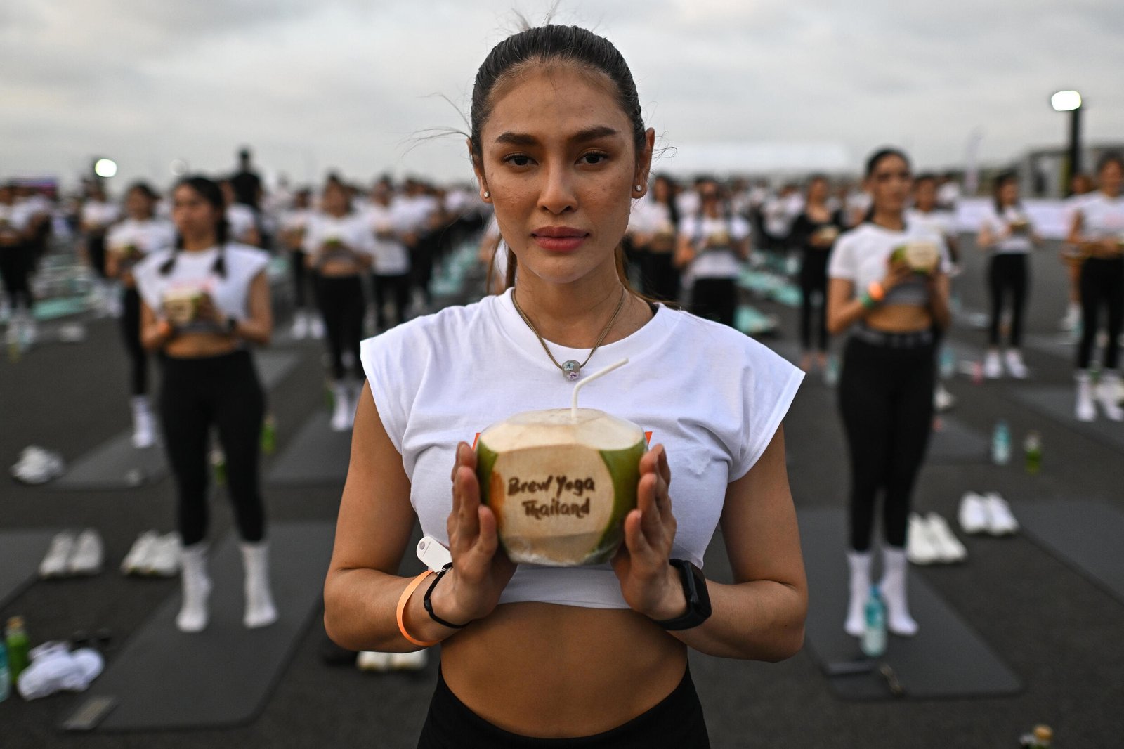 Un passionné de yoga tient une noix de coco lors de l'événement de yoga au lever du soleil
