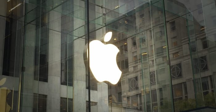 Logo Apple éclairé à l'intérieur d'un Apple Store.