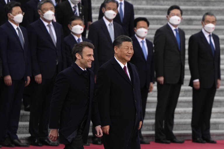DOSSIER- Le président français Emmanuel Macron marche avec le président chinois Xi Jinping lors d'une cérémonie de bienvenue qui s'est tenue devant le Grand Palais du Peuple à Pékin, le jeudi 6 avril 2023. Xi commencera sa tournée européenne à Paris les 6 et 7 mai 2024, rencontre avec Macron, qui a insisté sur l'idée d'une autonomie stratégique européenne par rapport aux États-Unis (AP Photo/Ng Han Guan, Pool, File)