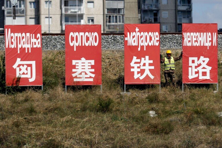 DOSSIER - Un ouvrier se repose entre des panneaux publicitaires indiquant : « Construction du chemin de fer serbo-hongrois » à Belgrade, en Serbie, le vendredi 4 septembre 2020. En 2014, la Hongrie et la Serbie ont conclu un accord avec Pékin pour moderniser le chemin de fer entre leurs capitales, Budapest et Belgrade, dans le cadre d'un plan 