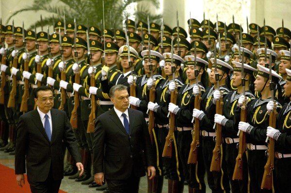 DOSSIER- Le Premier ministre hongrois Viktor Orban assiste à une cérémonie de bienvenue avec le Premier ministre chinois Li Keqiang, à gauche, au Grand Palais du Peuple à Pékin, en Chine, le mercredi 12 février 2014. La Hongrie est le premier membre de l'UE à participer à la signature de Xi. Initiative « la Ceinture et la Route » qui vise à construire des milliards de dollars de routes, de ports, de centrales électriques et d’autres infrastructures en Asie, en Afrique et au-delà.  (Photo AP/Ng Han Guan, dossier)
