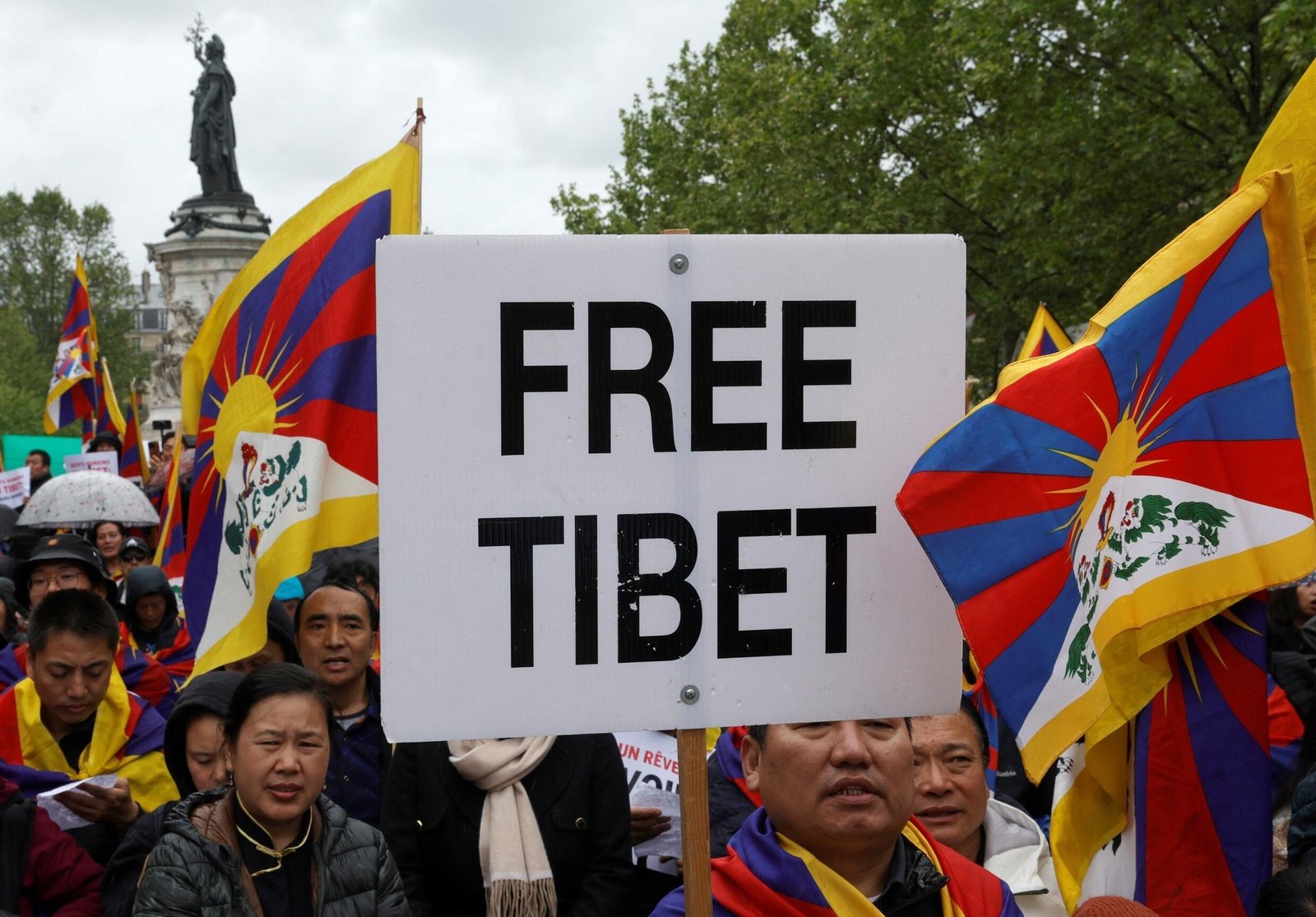 Des manifestants brandissent des drapeaux tibétains et brandissent une pancarte Tibet libre lors d'un rassemblement contre la visite du président chinois Xi Jinping en France le 5 mai 2024 à Paris.