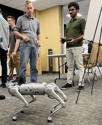 Electrical engineering grad student Shivayogi Akki (right), presents his research on Benchmarking Model Predictive Control and Reinforcement Learning for Legged Robot Locomotion at Showcase[AI]. On the left is Keith Vertanen, computer science faculty member.