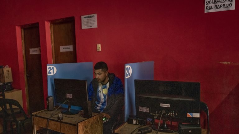 La crise économique en Argentine, une bénédiction déguisée pour les cybercafés 4 Une photo montrant un homme assis devant un ordinateur dans une pièce rouge.