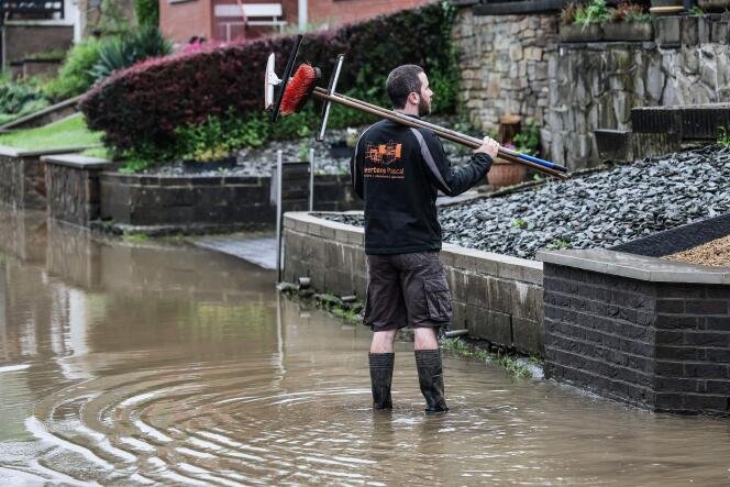 De fortes pluies en Europe du Nord provoquent des inondations 2 Un riverain tient des raclettes et des balayeuses dans une rue inondée au lendemain d'un épisode de fortes pluies à Trooz, en Belgique, le 18 mai 2024.