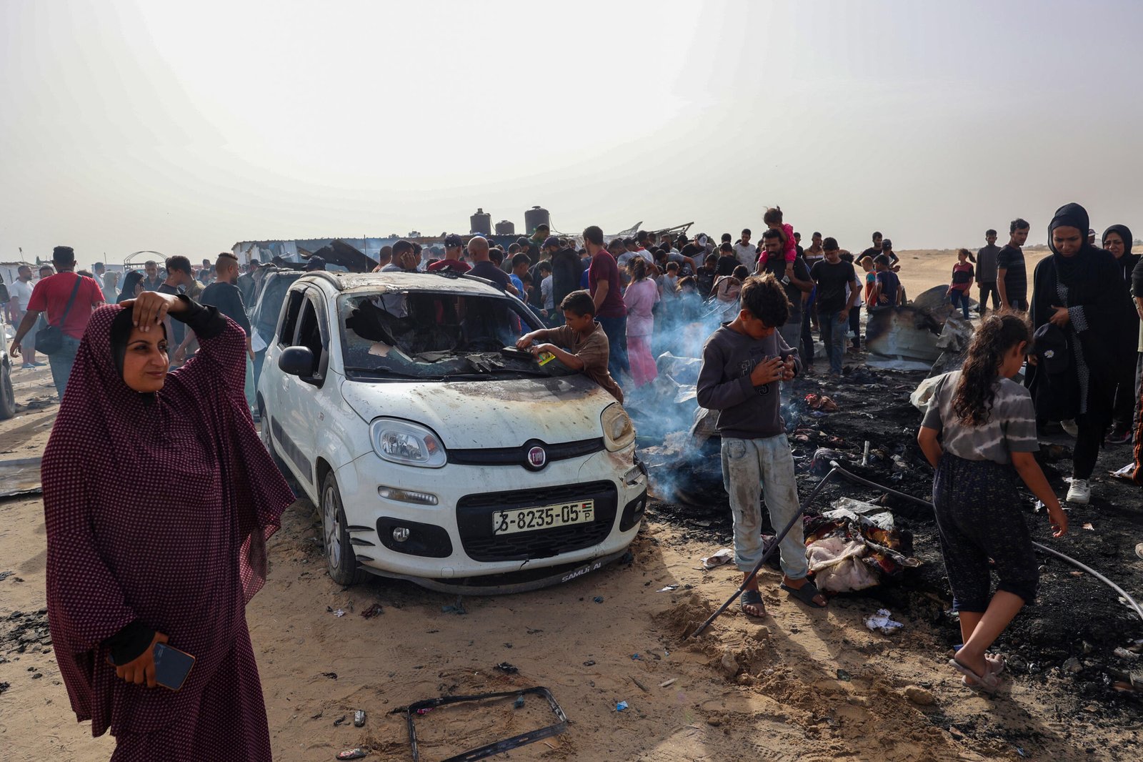 Des Palestiniens se rassemblent sur le site d'une frappe israélienne sur un camp abritant des personnes déplacées près de Rafah, le 27 mai 2024.