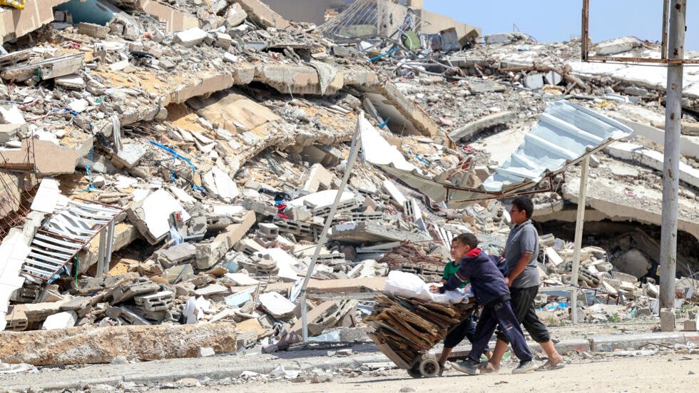 De jeunes Palestiniens collectent des cartons et des palettes en bois Beit Lahya, dans le nord de la bande de Gaza, le 4 mai 2024.