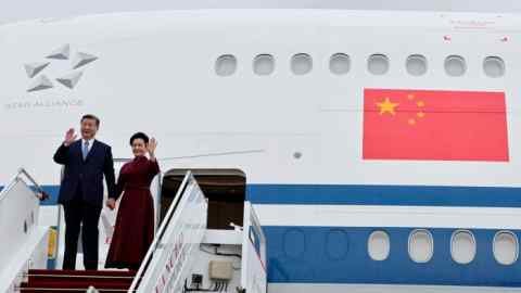 Le président chinois Xi Jinping et son épouse Peng Liyuan saluent depuis un avion à leur arrivée à Paris pour une visite d'État officielle de deux jours en France dimanche.