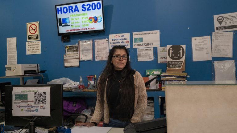 La crise économique en Argentine, une bénédiction déguisée pour les cybercafés 1 Photo d’une femme debout derrière un bureau dans une pièce au mur bleu.