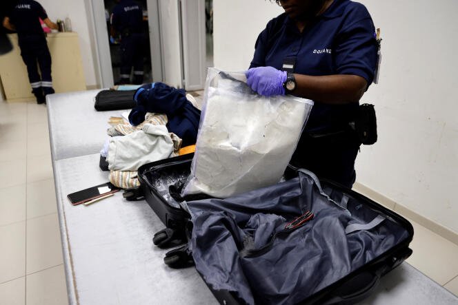 Les douaniers français découvrent de la cocaïne cachée dans une valise alors qu'ils inspectent les bagages d'un passager à destination de Paris à l'aéroport international de Cayenne, en Guyane française, le 24 mars 2024.