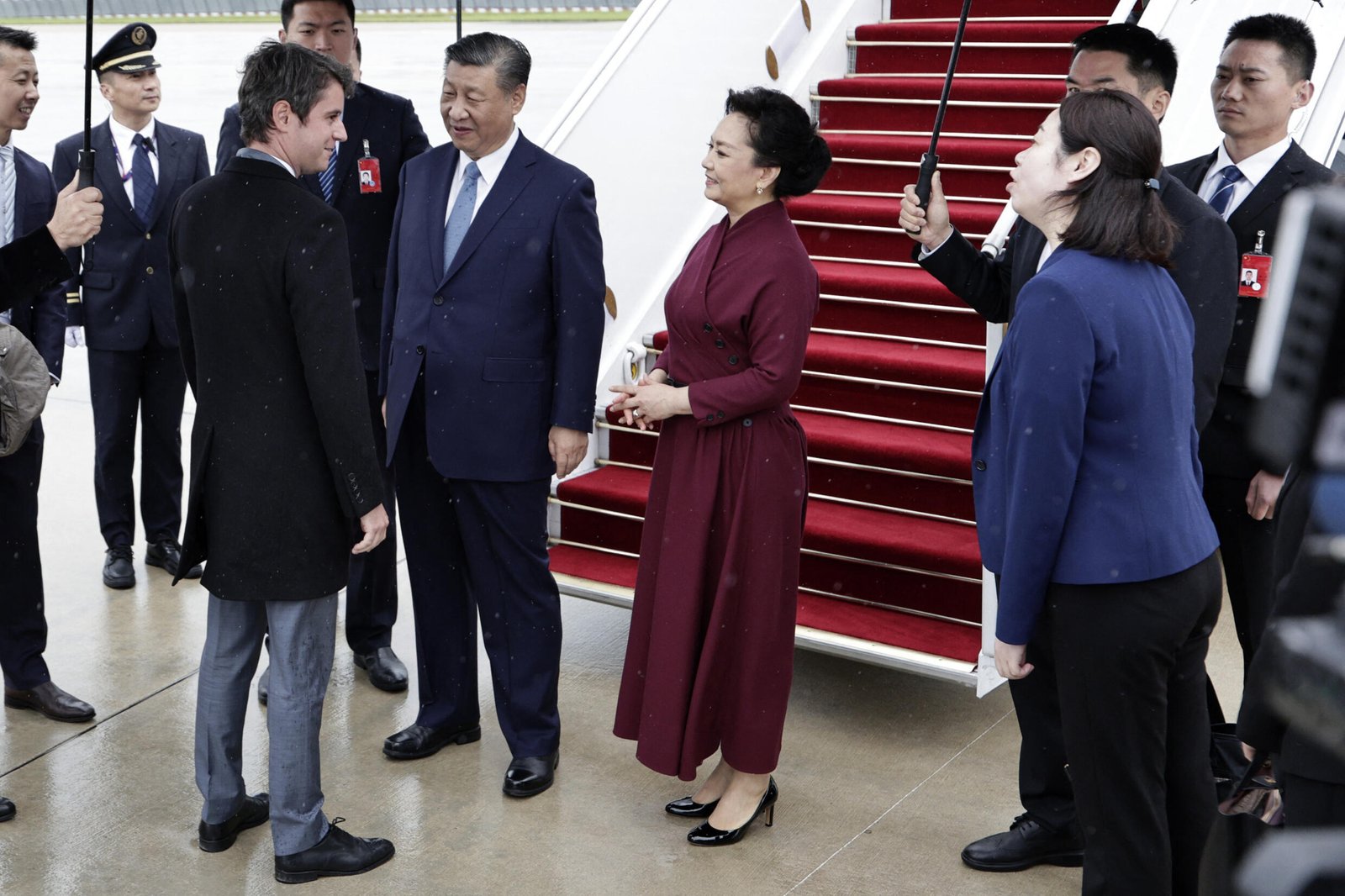Le Premier ministre français Gabriel Attal (à gauche) accueille le président chinois Xi Jinping et son épouse Peng Liyuan à leur arrivée pour une visite d'État officielle de deux jours à l'aéroport d'Orly le 5 mai 2024.