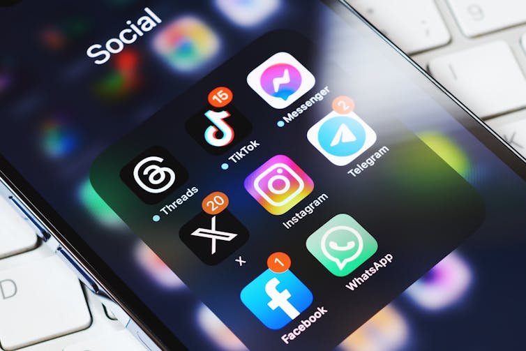 Gros plan sur l'écran d'un téléphone mobile affichant plusieurs applications de médias sociaux.