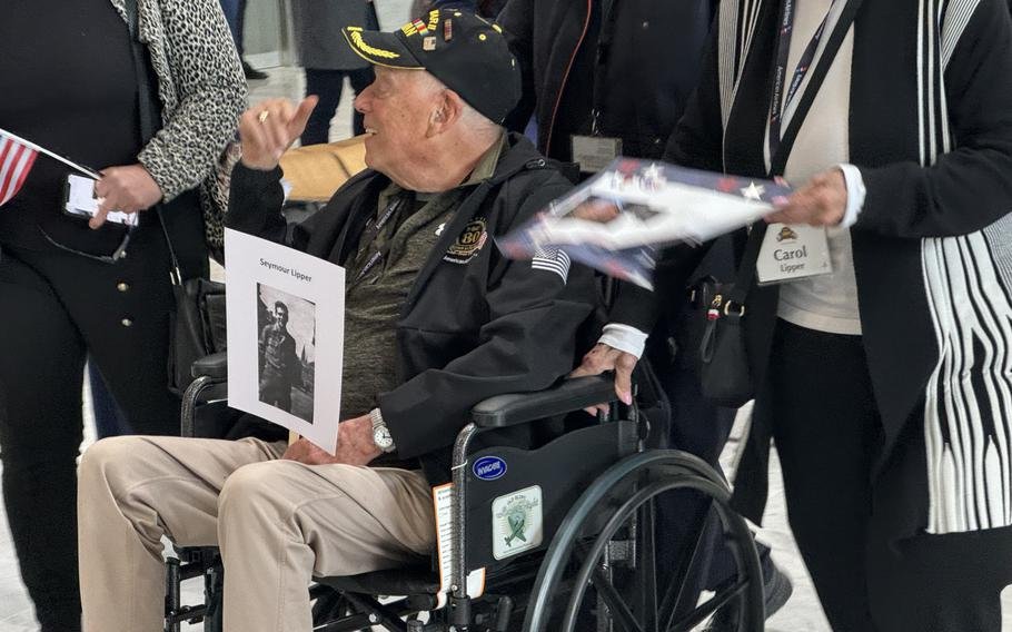 Le vétéran Seymour Lipper, qui a combattu dans l'artillerie lors de la bataille des Ardennes, salue ses sympathisants à son arrivée à Paris pour les commémorations du jour J.