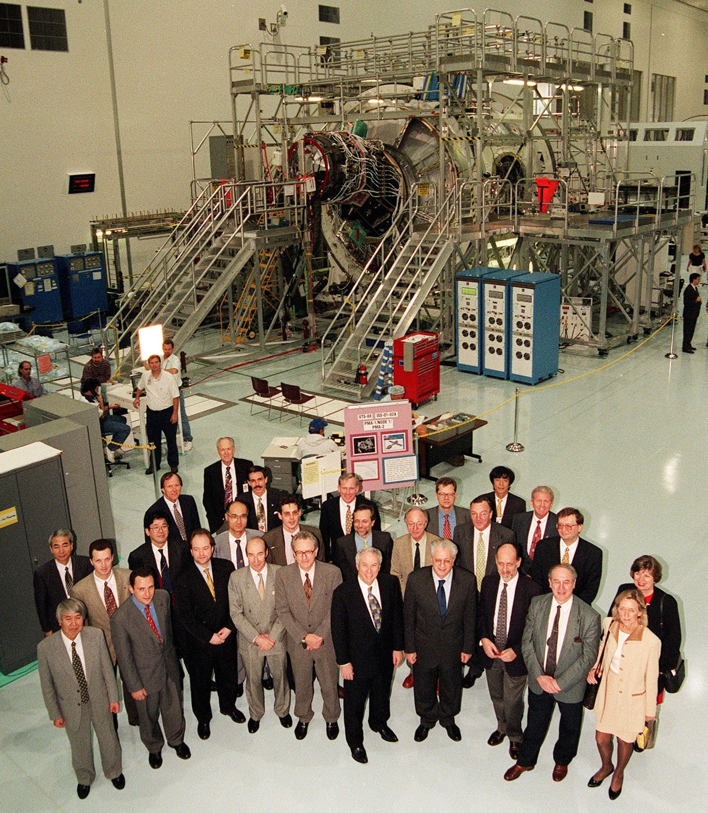 Les signataires de l'IGA de 1998 visitent l'installation de traitement de la station spatiale du centre spatial Kennedy de la NASA en Floride, posant devant le module Unity Node 1 en préparation pour le lancement.