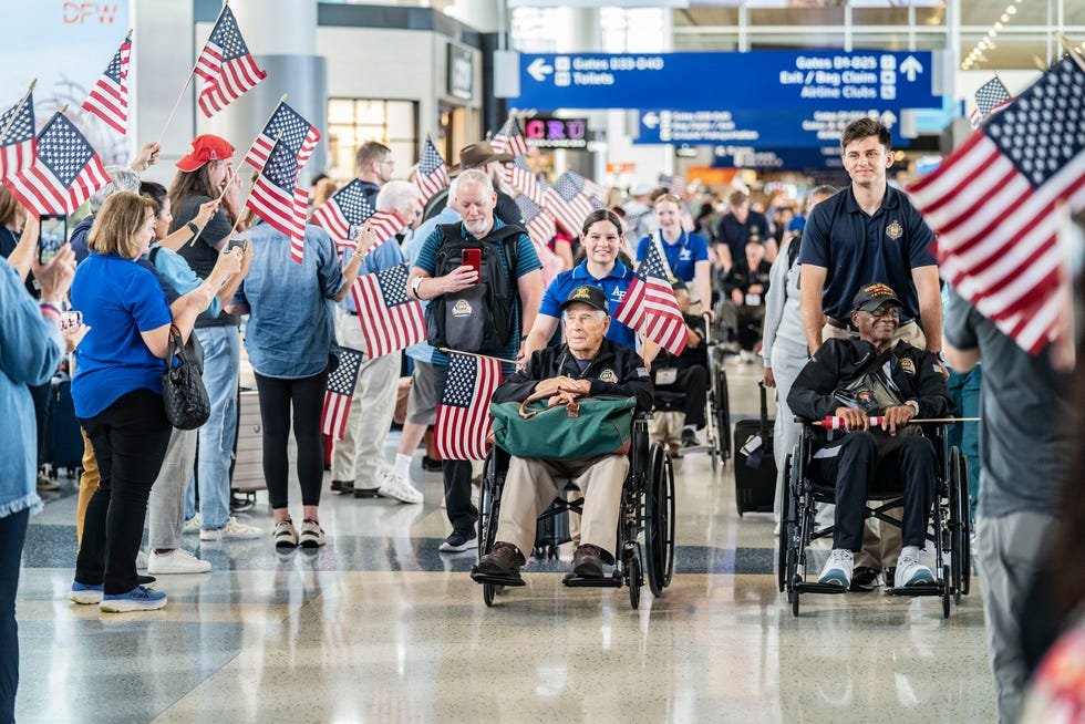 The group, mostly in wheelchairs, rolled past the gates on their way toward an overnight flight to Paris.