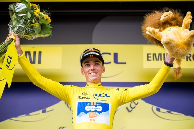 Le Français Romain Bardet de l'équipe DSM-Firmenich PostNL portant le maillot jaune de leader au classement par points célèbre sur le podium après la première étape du Tour de France 2024 de Florence, en Italie, à Rimini, en Italie. (Photo de JASPER JACOBS/BELGA MAG/AFP via Getty Images)