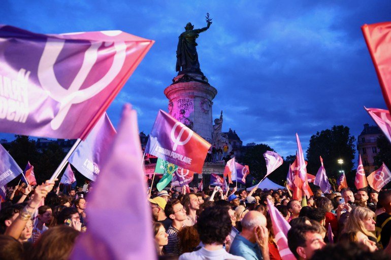 Un rassemblement de soutien au Nouveau Front Populaire (NFP) et contre le RN à Paris. Les gens brandissent des drapeaux et des banderoles du NFP