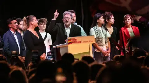 ARNAUD FINISTRE/AFP Jean-Luc Mélenchon (au centre) fait un geste en prononçant un discours à côté de membres du parti LFI
