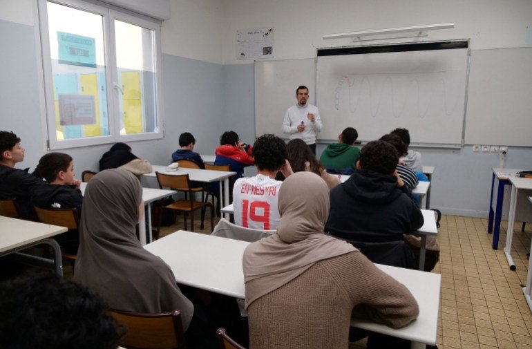 Des collégiens, certains portant un hijab, écoutent le professeur Ilyas Laarej lors d'un cours d'éthique islamique à l'école Averroès, le plus grand établissement d'enseignement musulman de France