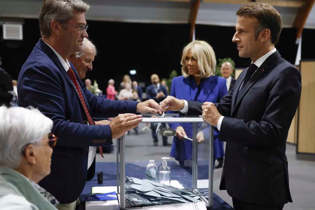 Le président français Emmanuel Macron, à droite, vote pour le second tour des élections législatives au Touquet-Paris-Plage, dans le nord de la France, dimanche.
