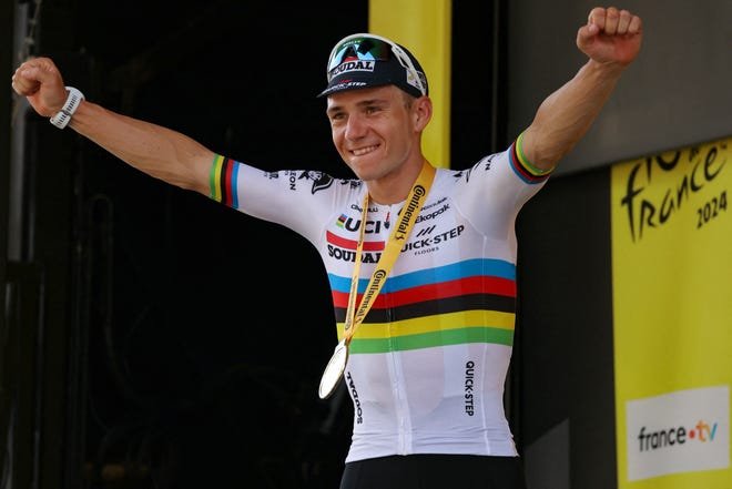 Le coureur belge Remco Evenepoel célèbre sur le podium après avoir remporté la septième étape.